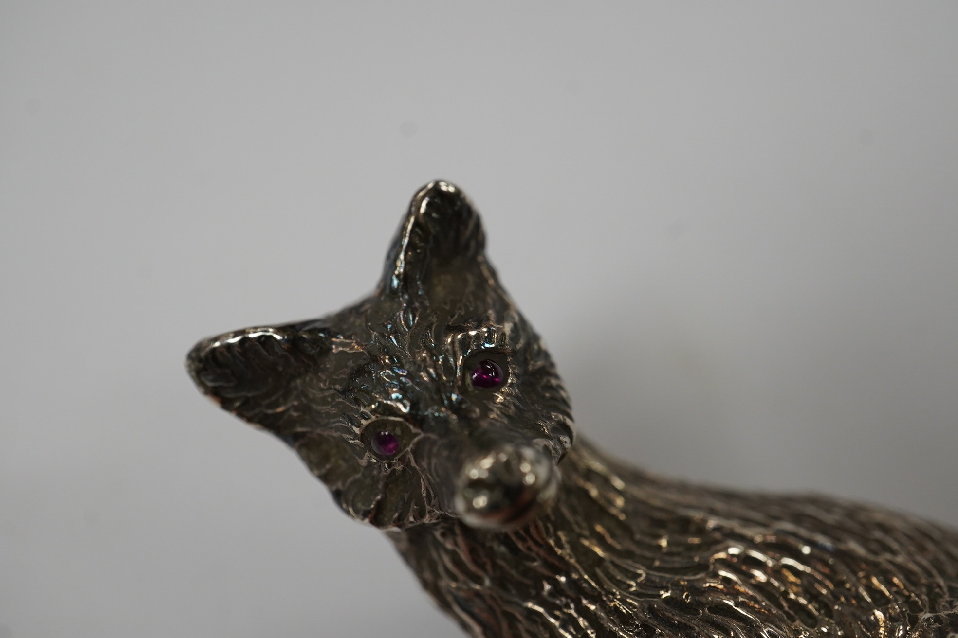 Two 1960's silver miniature models of a fox, both London, 1968, seated by Edward Barnard & Sons Ltd, height 38mm and one other smaller silver model of a running fox, 6.7oz. Condition - fair to good